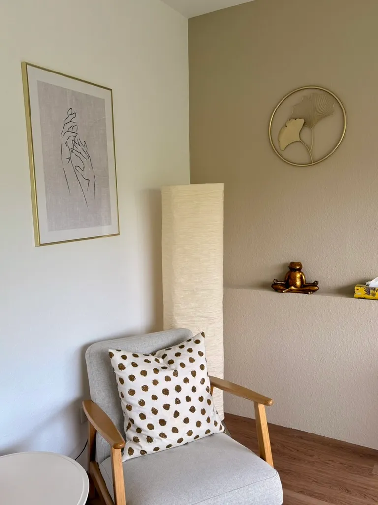 Gemütliche Sitzecke mit Sessel, Wandbild und Leuchte